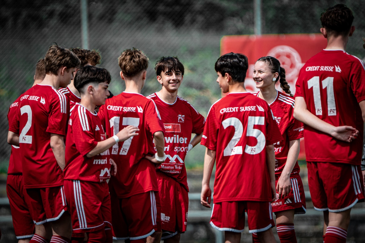 Team-Moment mit lachenden Fussballspielern vor dem Spiel
